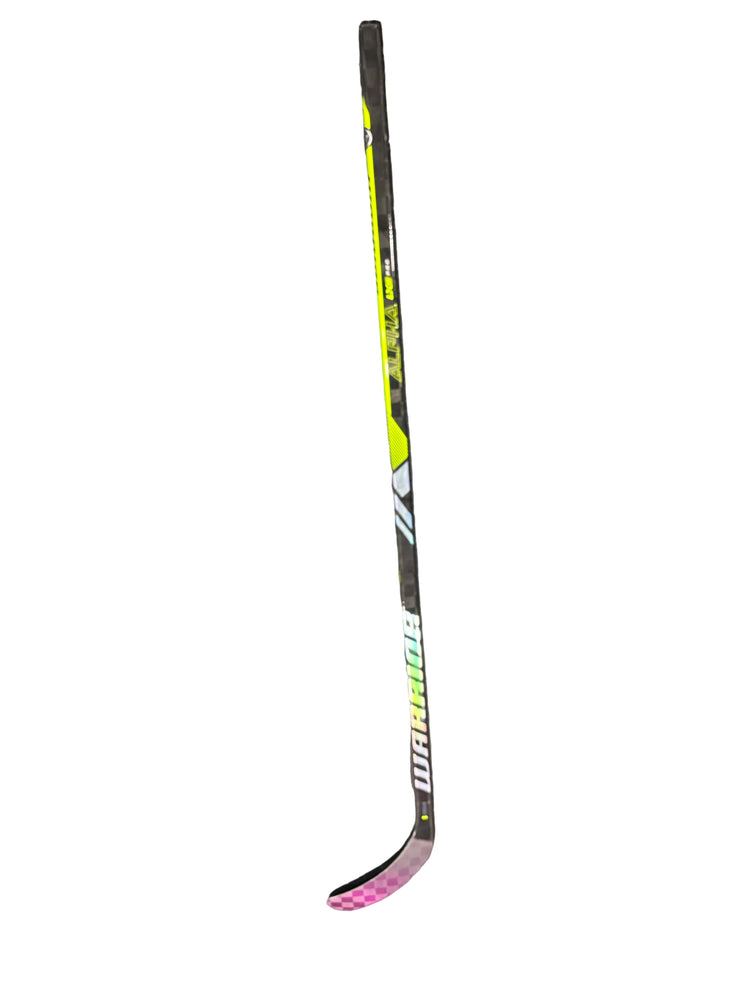 Hockey stick with Warrior branding on a gray surface
